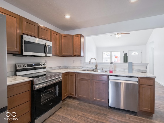 kitchen featuring sink, dark hardwood / wood-style flooring, lofted ceiling, and stainless steel appliances