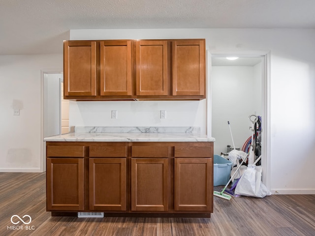 kitchen with a textured ceiling and dark wood-type flooring