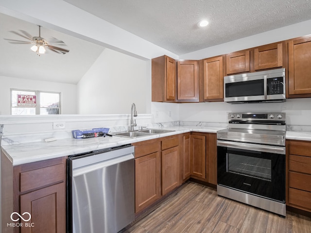 kitchen featuring lofted ceiling, dark wood-type flooring, sink, a textured ceiling, and stainless steel appliances