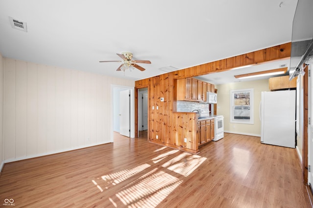 100 N Jefferson St, Nashville, IN 47448 - kitchen featuring white appliances, a ceiling fan, light countertops, light wood finished floors, and brown cabinetry