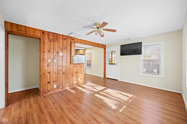 100 N Jefferson St, Nashville, IN 47448 - unfurnished living room featuring ceiling fan, light wood-style flooring, and wooden walls