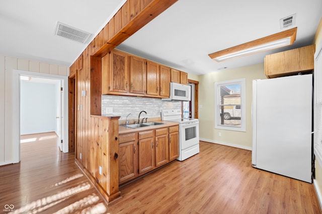 100 N Jefferson St, Nashville, IN 47448 - kitchen with white appliances, light wood-style flooring, tasteful backsplash, and light countertops