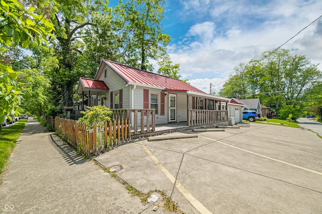 100 N Jefferson St, Nashville, IN 47448 - view of front facade featuring covered porch, uncovered parking, and a metal roof