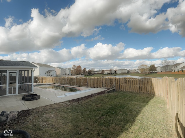 view of yard featuring a fenced in pool, a sunroom, and a patio area