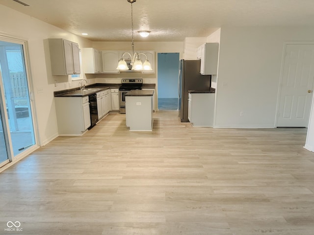 kitchen featuring sink, decorative light fixtures, a chandelier, a center island, and appliances with stainless steel finishes