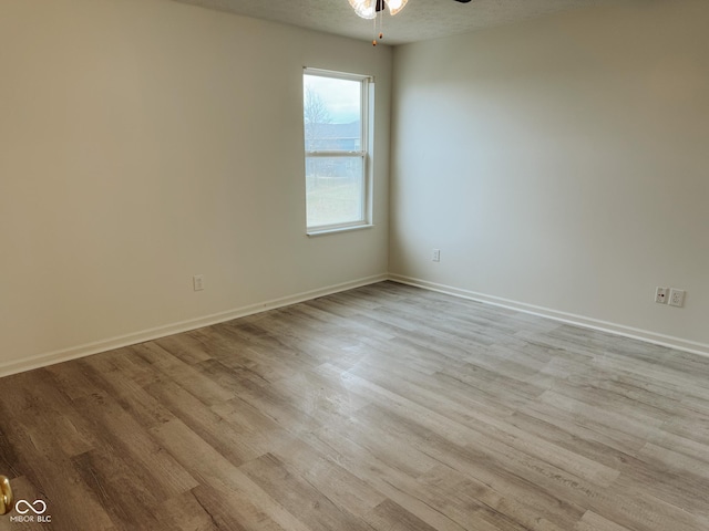 spare room featuring a textured ceiling, ceiling fan, and light wood-type flooring