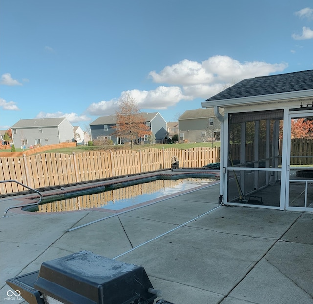 view of swimming pool with a sunroom and a patio