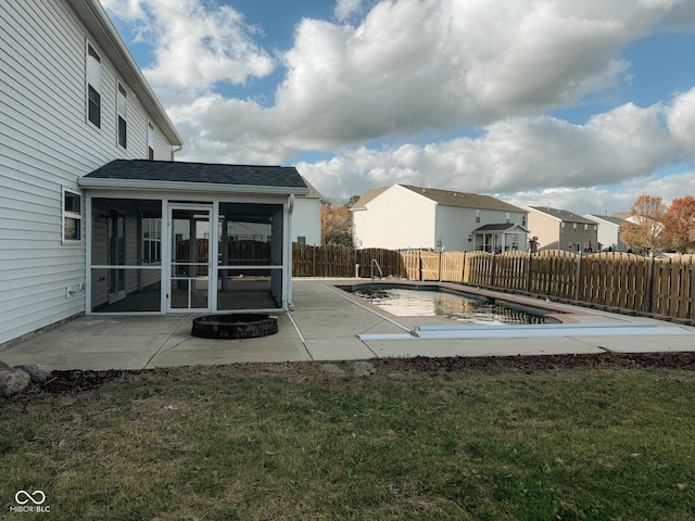 view of pool featuring a sunroom, a yard, and a patio area