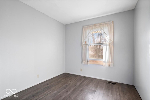 spare room with dark hardwood / wood-style floors