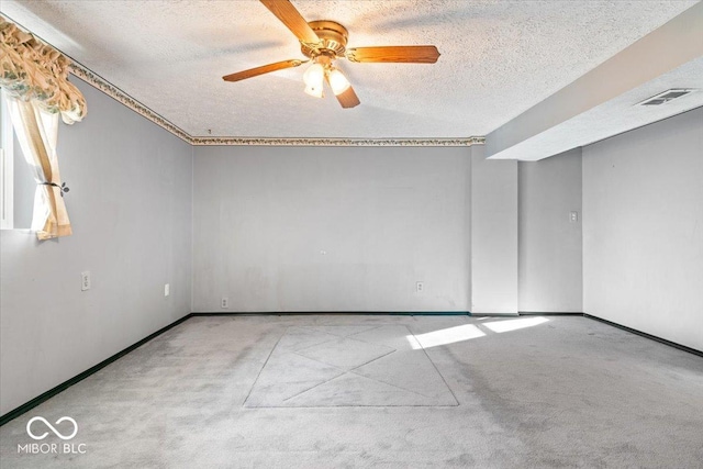 carpeted spare room with ceiling fan and a textured ceiling