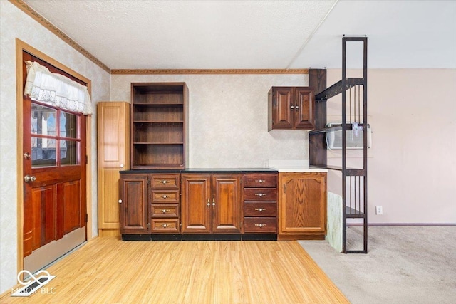 interior space with ornamental molding, a textured ceiling, and light wood-type flooring