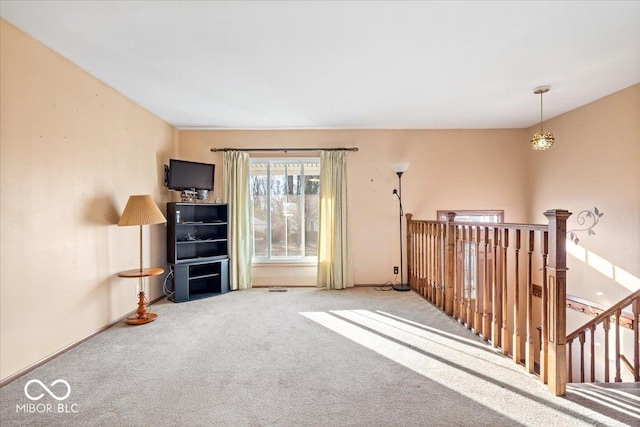 carpeted spare room with a chandelier