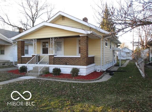 bungalow-style home with a front lawn and a porch