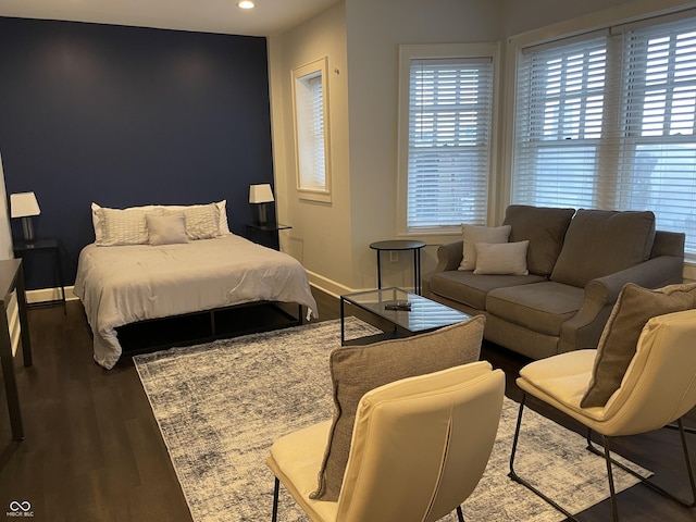 bedroom with dark hardwood / wood-style flooring and multiple windows