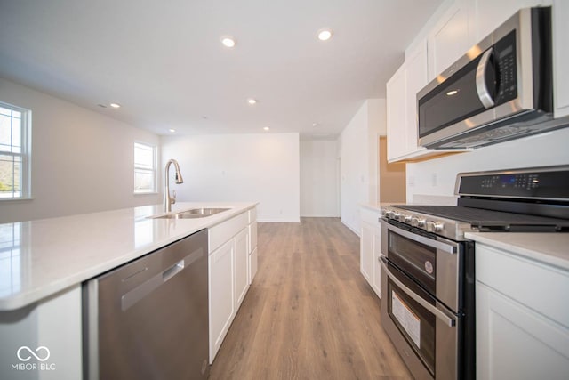 kitchen featuring sink, white cabinetry, stainless steel appliances, and light wood-type flooring