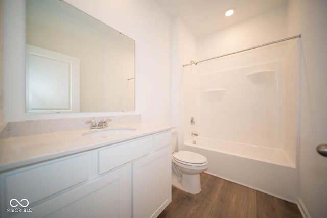 full bathroom featuring hardwood / wood-style flooring, toilet, vanity, and shower / bathing tub combination