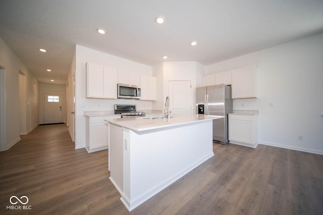 kitchen with sink, white cabinetry, stainless steel appliances, and a kitchen island with sink