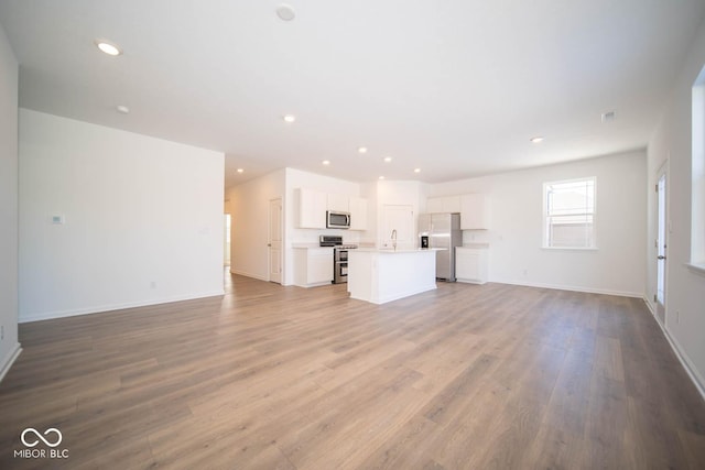 unfurnished living room with sink and light hardwood / wood-style flooring