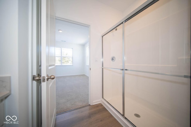 bathroom featuring hardwood / wood-style floors and walk in shower