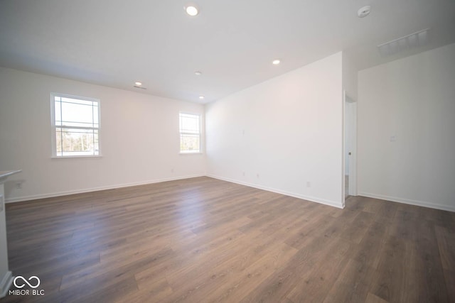 empty room featuring a healthy amount of sunlight and dark hardwood / wood-style floors