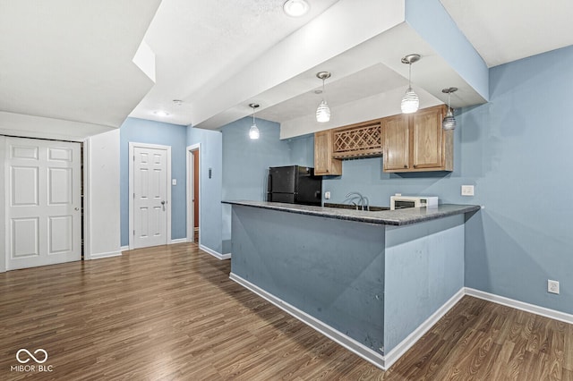 kitchen featuring freestanding refrigerator, dark wood-style flooring, baseboards, and white microwave