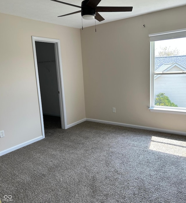 carpeted spare room featuring a ceiling fan and baseboards