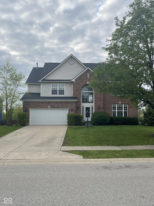 traditional-style home with brick siding, a front yard, concrete driveway, and an attached garage
