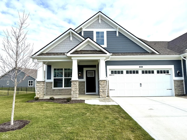 craftsman inspired home featuring covered porch, a front yard, and a garage