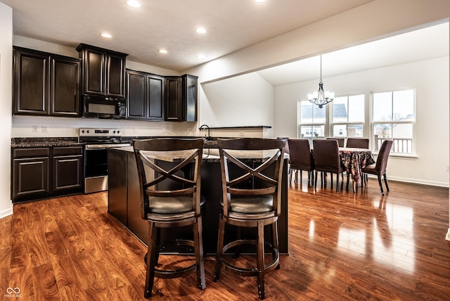 kitchen featuring a kitchen breakfast bar, dark hardwood / wood-style floors, pendant lighting, a chandelier, and stainless steel range with electric cooktop