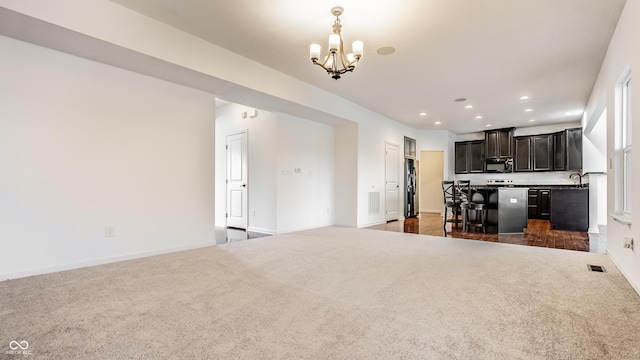 unfurnished living room with a chandelier and dark carpet