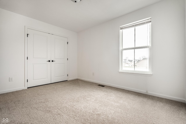 unfurnished bedroom with carpet flooring and a closet