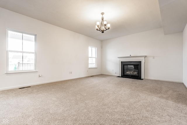 unfurnished living room with carpet and an inviting chandelier