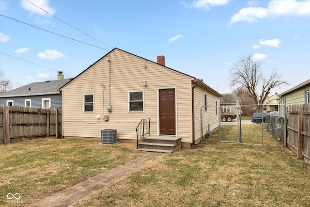 rear view of house with a yard and cooling unit