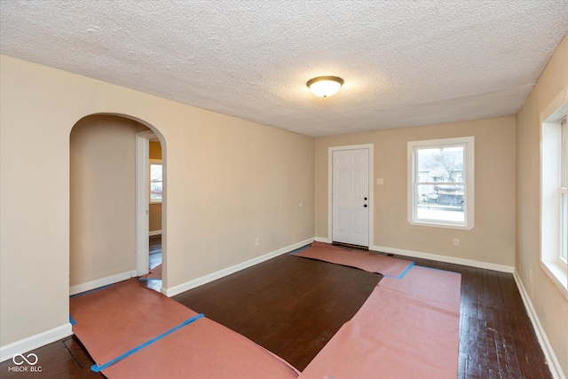 foyer entrance with dark wood-type flooring and a textured ceiling