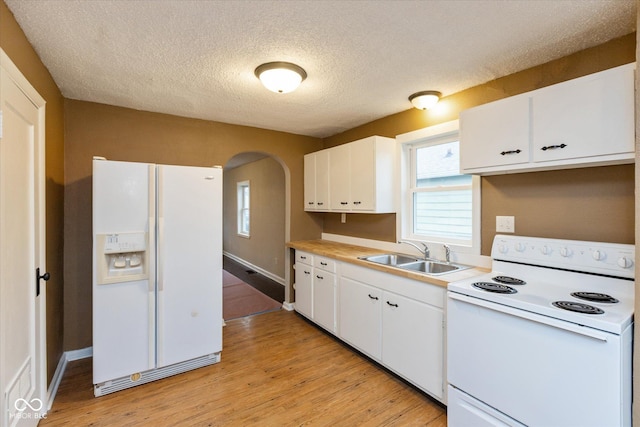 kitchen with white appliances, sink, a textured ceiling, light hardwood / wood-style floors, and white cabinetry