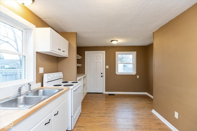 kitchen featuring a textured ceiling, sink, electric range, white cabinets, and light hardwood / wood-style floors