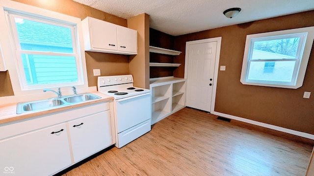 kitchen featuring sink, a textured ceiling, white electric range oven, light hardwood / wood-style floors, and white cabinetry