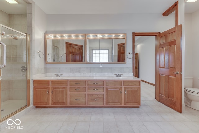 bathroom with tile patterned floors, vanity, toilet, and a shower with door