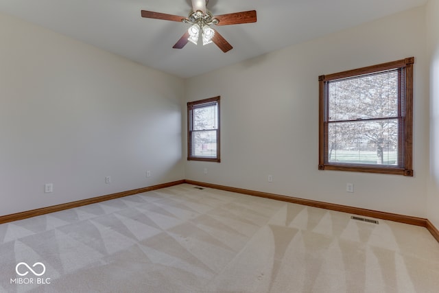 carpeted spare room featuring ceiling fan