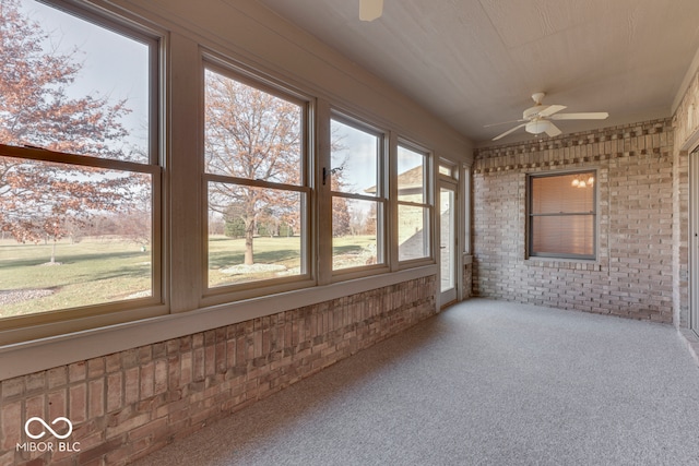 unfurnished sunroom featuring a wealth of natural light and ceiling fan