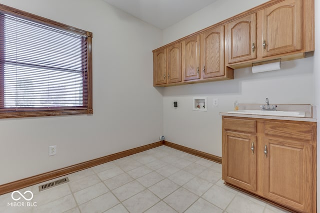 laundry room featuring hookup for a washing machine, sink, light tile patterned floors, and cabinets