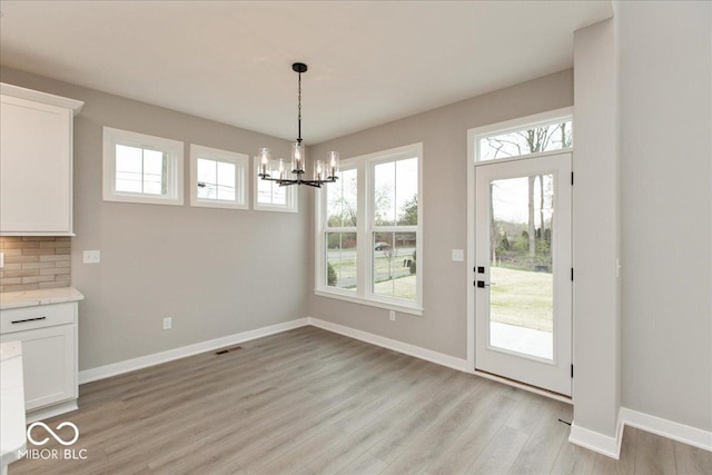 6973 Oakdale Ln, Avon, IN 46123 - unfurnished dining area with light wood-style flooring, an inviting chandelier, baseboards, and a wealth of natural light