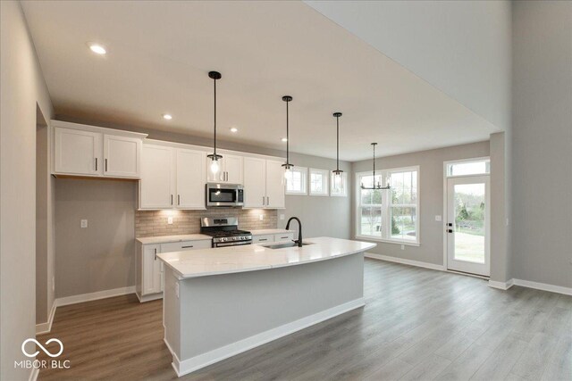 6973 Oakdale Ln, Avon, IN 46123 - kitchen with a sink, white cabinets, appliances with stainless steel finishes, and wood finished floors