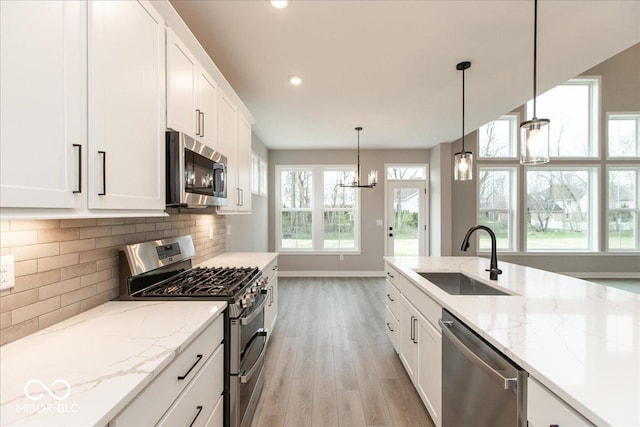 6973 Oakdale Ln, Avon, IN 46123 - kitchen with light wood-type flooring, white cabinetry, a sink, stainless steel appliances, and baseboards
