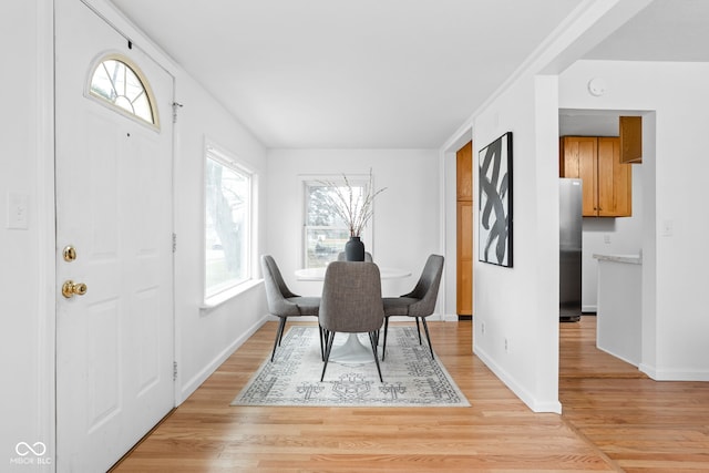 dining space with light hardwood / wood-style flooring and plenty of natural light