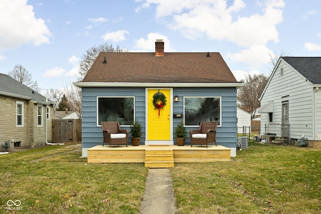 view of front facade with a wooden deck and a front yard