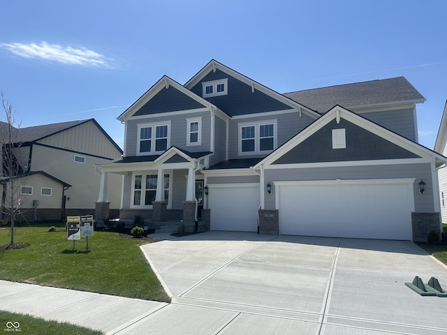craftsman-style house with driveway, a front lawn, brick siding, and a garage