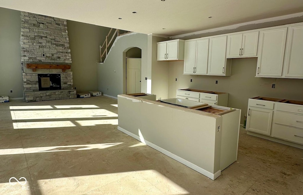 kitchen featuring a fireplace, white cabinetry, and a center island