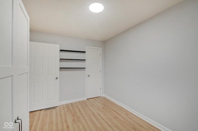 unfurnished bedroom featuring light hardwood / wood-style floors and a closet