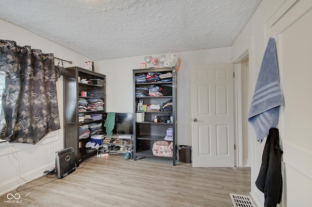 interior space featuring light hardwood / wood-style flooring and a textured ceiling